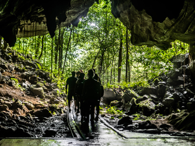 Wandelaars verlaten een grot en lopen het regenwoud in op Maleisisch Borneo tijdens de Route Maleisisch Borneo.
