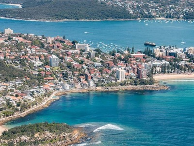 Uitzicht over Manly en Sydney Harbour met stranden, bebouwing en zeilboten tijdens de Australië kampeer- & hotelreis.