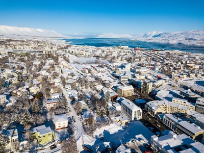 Sneeuwbedekte stad Akureyri aan de fjord in Noord-IJsland, met bergen op de achtergrond.
