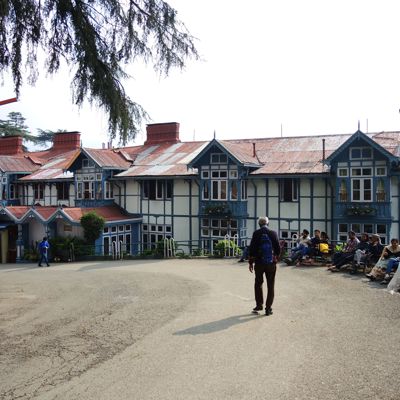 Wandelaar met rugzak bij koloniale gebouwen in Shimla, India, tijdens groepsrondreis Spiti & Ladakh.