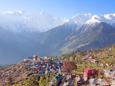 Dorp in de Himalaya met gekleurde daken en besneeuwde bergtoppen tijdens de Route Spiti & Ladakh.