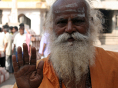 Hindoestaanse sadhu met lange witte baard geeft een zegenend gebaar tijdens de route door Zuid-India.