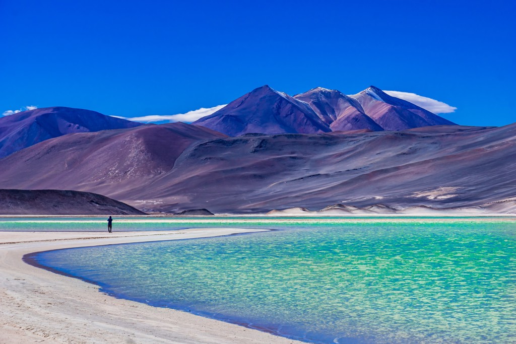 Turquoise lagune in de Andes met vulkanen op de achtergrond tijdens groepsrondreis Bolivia en Chili.