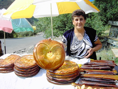 Vrouw verkoopt traditioneel gebak langs de weg tijdens de route Armenië en Georgië, 18 dagen.