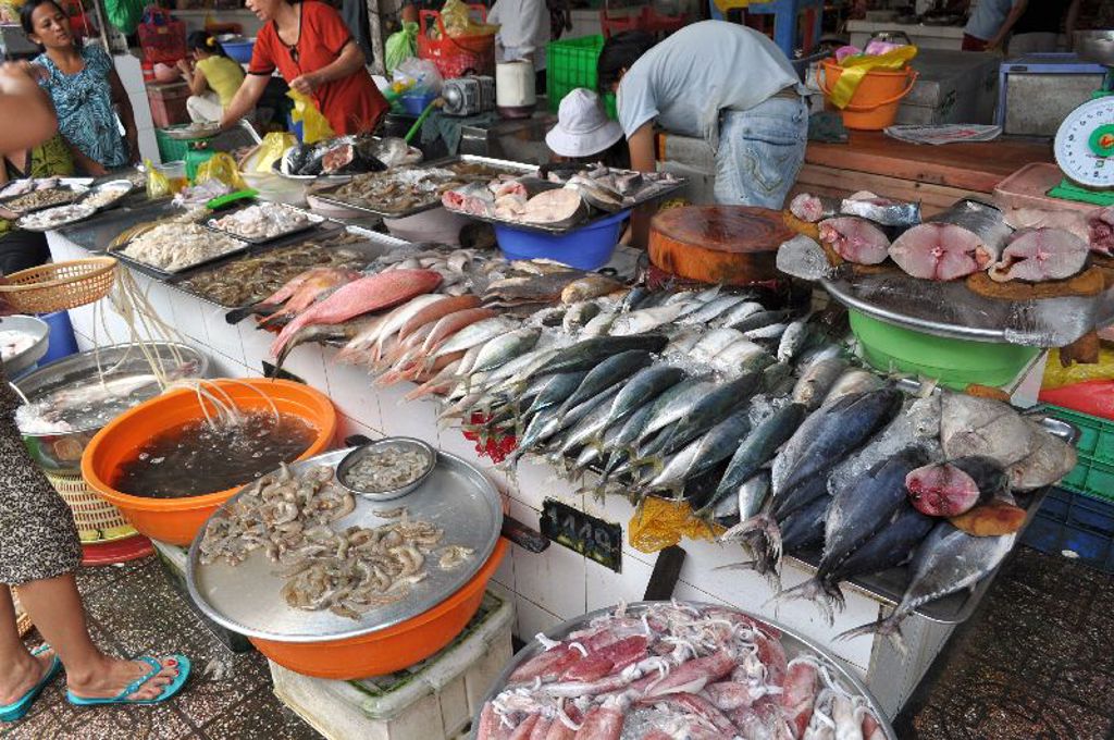 Viskraam op een markt in Vietnam met verse vis, garnalen en inktvis op ijs.