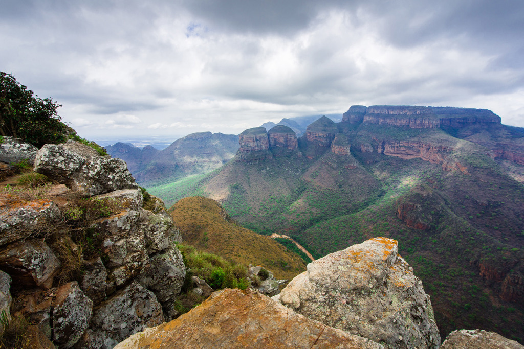 Uitzicht over de Blyde River Canyon en de Drie Rondavels in Zuid-Afrika onder een bewolkte lucht.