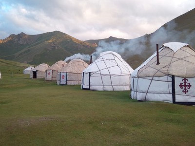 Yurtkamp in de bergen van Kirgistan langs de Zijderoute, met rook uit de schoorstenen.