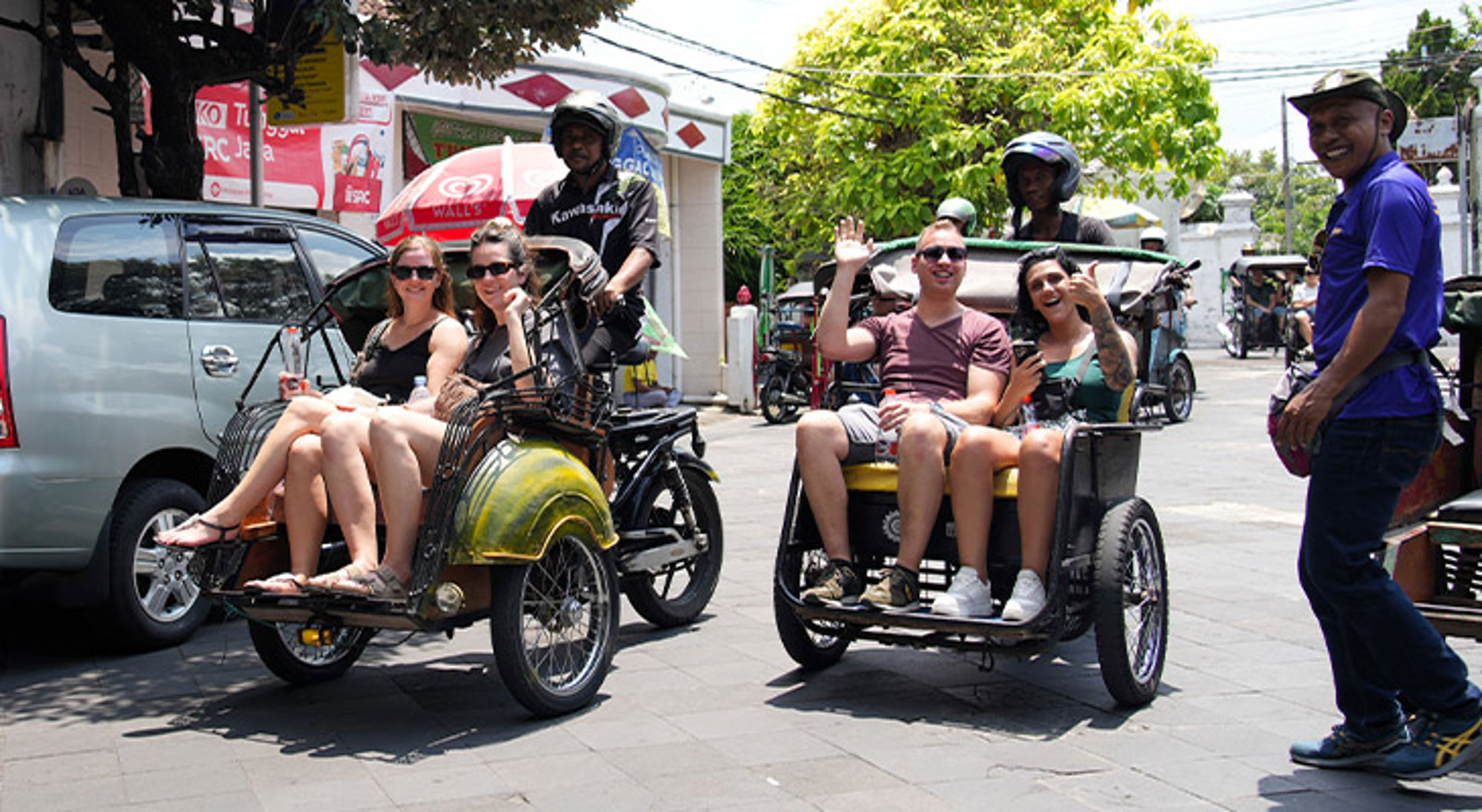 Yogyakarta Java Toeristen rijden in fietstaxi’s door de stad en zwaaien naar de camera.