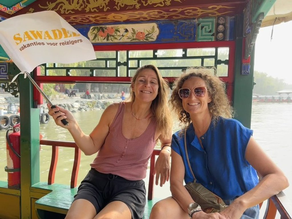Reizigers op een boot in China tijdens groepsrondreis China, met Sawadee-vlag.