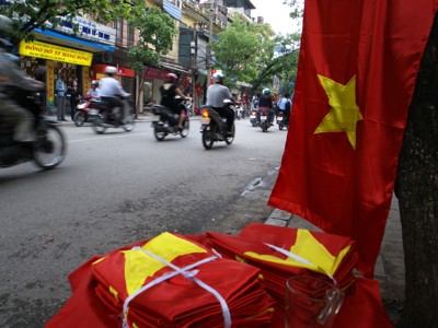 Vietnamese vlaggen langs een drukke straat met scooters in Hanoi, Route Vietnam.