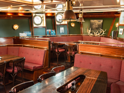Interieur van een schip met houten banken en tafels in de lounge.