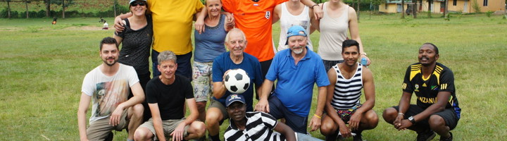 Groepsfoto van reizigers op een sportveld tijdens groepsreis Kenia, Tanzania en Zanzibar.