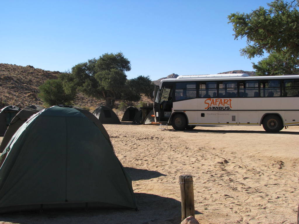 Kampeerplek met tenten en Safaribus tijdens familiereis Namibië, Botswana en Zimbabwe.