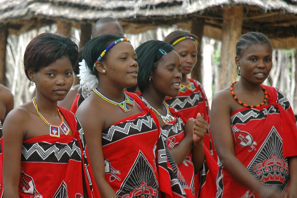 Swazi vrouwen in traditionele rode kledij tijdens een culturele ontmoeting op familiereis Zuid-Afrika en eSwatini.