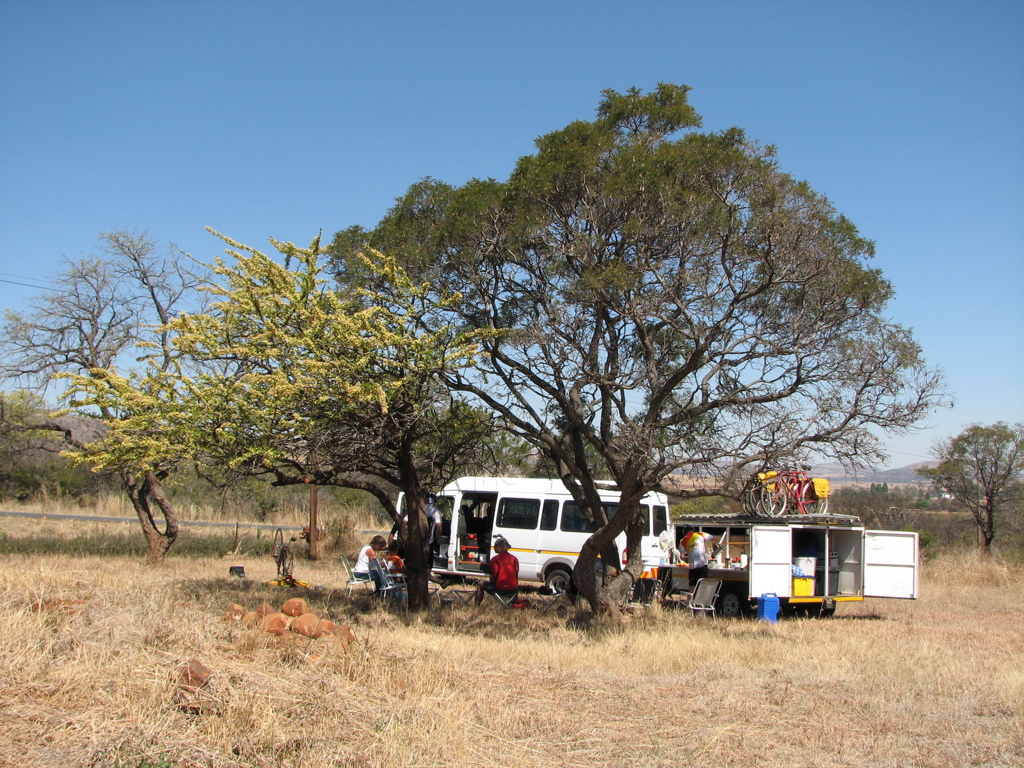 Picknickpauze tijdens fietsvakantie in Zuid-Afrika, met supportbus en fietsen in de savanne.