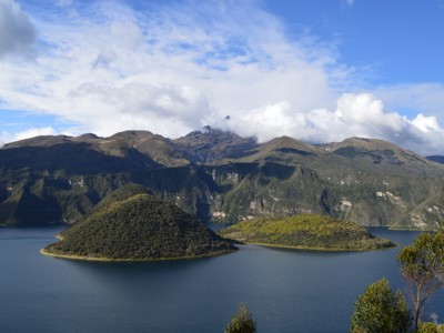 Uitzicht op het kratermeer Cuicocha met eilandjes en Andesbergen in Ecuador.