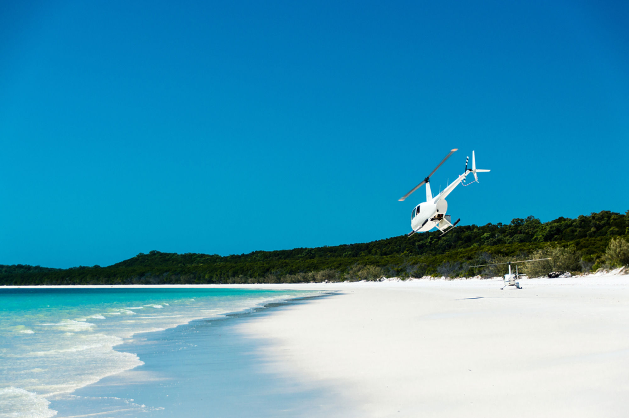 Luchtfoto van tropisch eiland met witte stranden en turquoise zee.