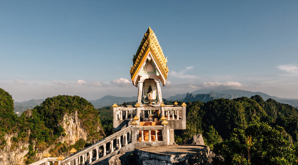 Gouden tempel op een uitkijkpunt met uitzicht op groene heuvels in Thailand tijdens groepsrondreis Singapore, Maleisië & Thailand.