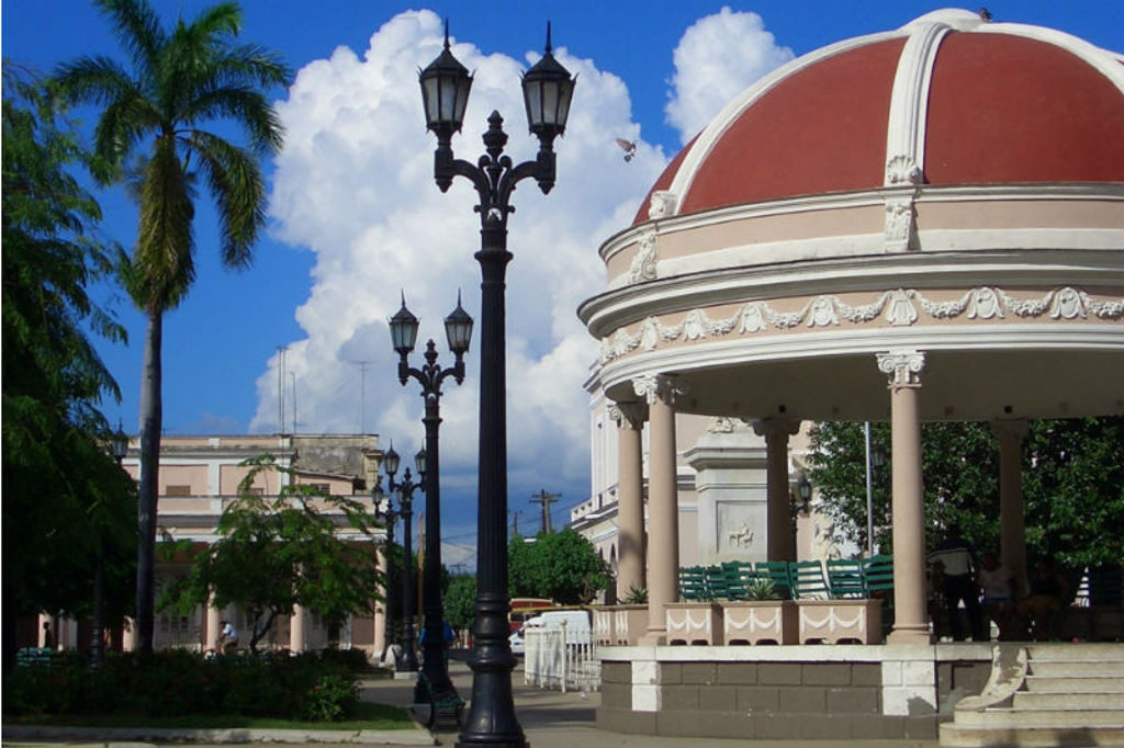 Koepelpaviljoen op een plein in Cuba met palmbomen en klassieke straatlantaarns.