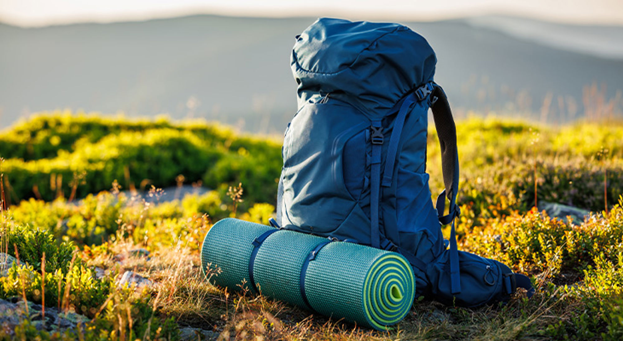 Backpack Rugzak met slaapmat in berglandschap, klaar voor een wandel- of trektocht.