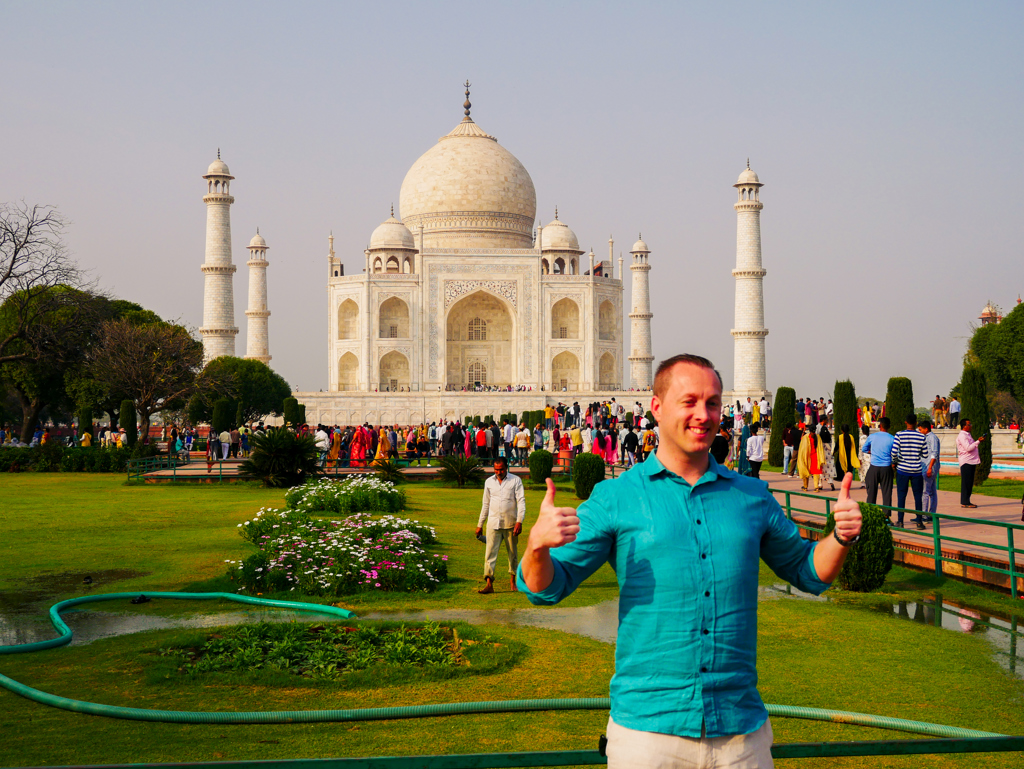 Reiziger poseert met duimen omhoog voor de Taj Mahal tijdens 22-35ers reis India.