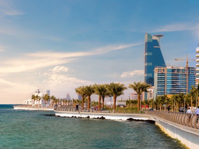 Corniche van Jeddah aan de Rode Zee met palmbomen, boulevard en moderne skyline in Saoedi-Arabië.