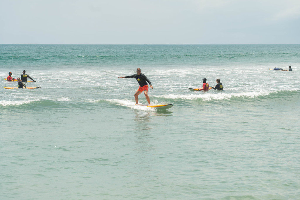 Surfer op een longboard in de golven bij Bali, Indonesië.