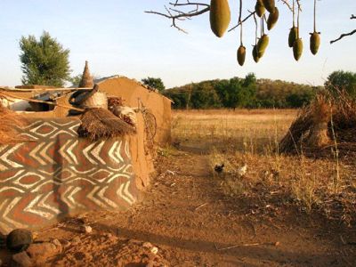 Traditionele lemen hut met beschilderde muur in het savannelandschap van Ghana, Togo en Benin.