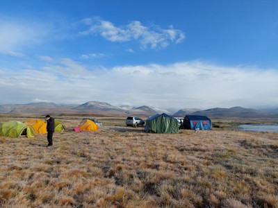 Tenten in een kamp op de hoogvlakte van Pakistan, met bergen op de achtergrond.