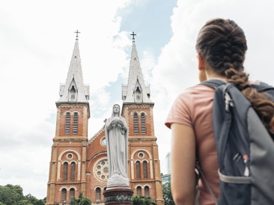 Reiziger bij de Notre-Dame-kathedraal in Ho Chi Minhstad tijdens de Route Vietnam.