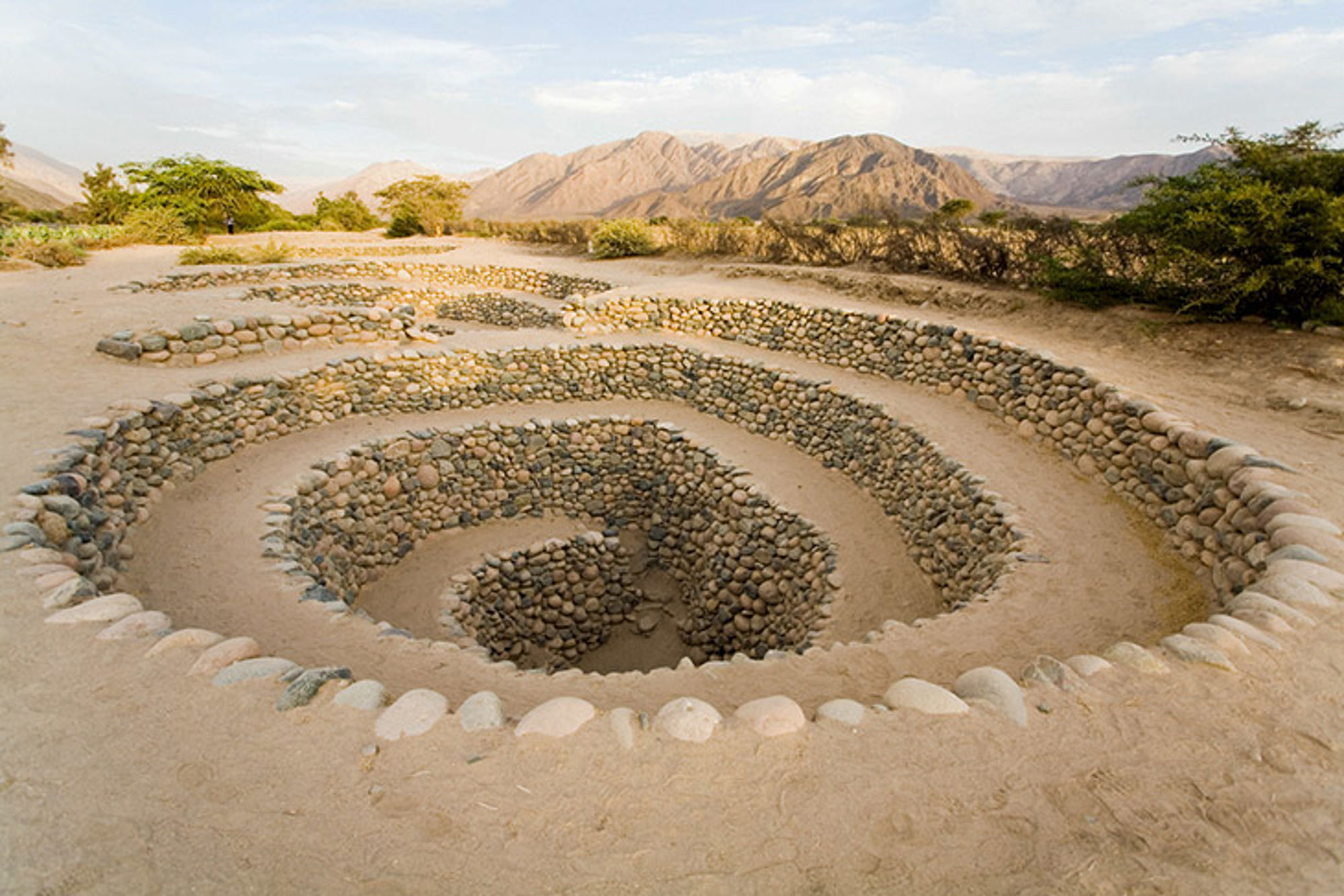 Natuur in Peru Spiraalvormige stenen ruïne in woestijnlandschap met bergen op de achtergrond.