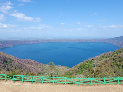 Uitzicht over het kratermeer Laguna de Apoyo in Nicaragua, omringd door groene heuvels.