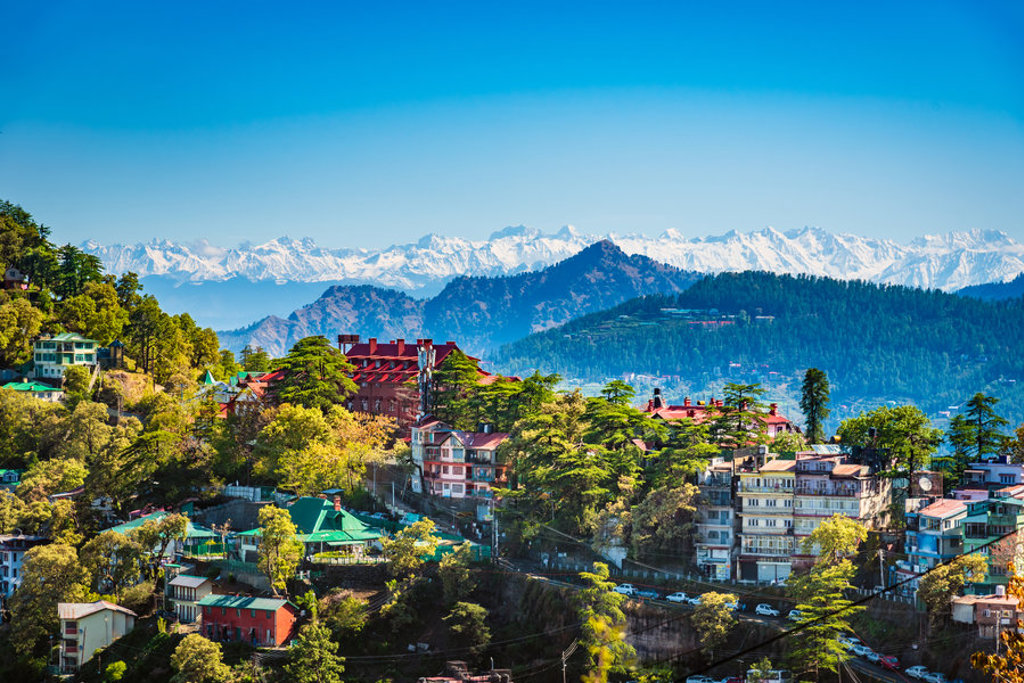 Uitzicht op Shimla met groene heuvels en besneeuwde Himalaya op de achtergrond tijdens groepsrondreis India Spiti & Ladakh.