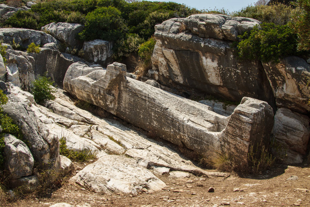 Oude marmeren zuil tussen rotsen op Naxos, tijdens wandelvakantie in Griekenland.