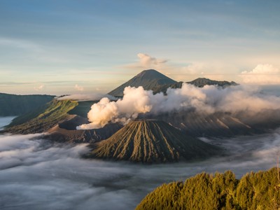 Zonsopkomst bij de Bromo-vulkaan op Java, met rokende krater en wolken boven het Tengger-massief.