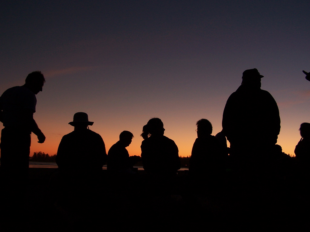 Silhouetten van reizigers bij zonsondergang tijdens groepsrondreis Canada West.