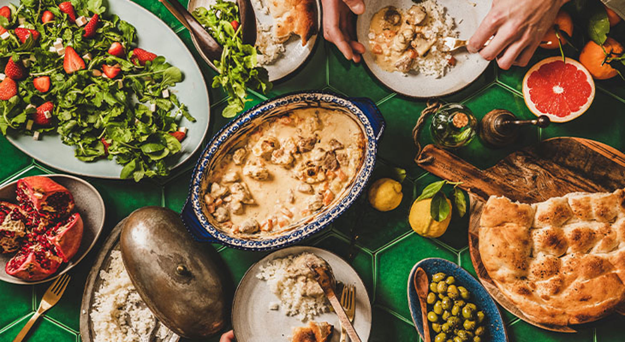 Ramadan Turkije Tafel met Midden-Oosterse gerechten, waaronder stoofschotel met rijst, platbrood, salade met aardbeien en olijven.