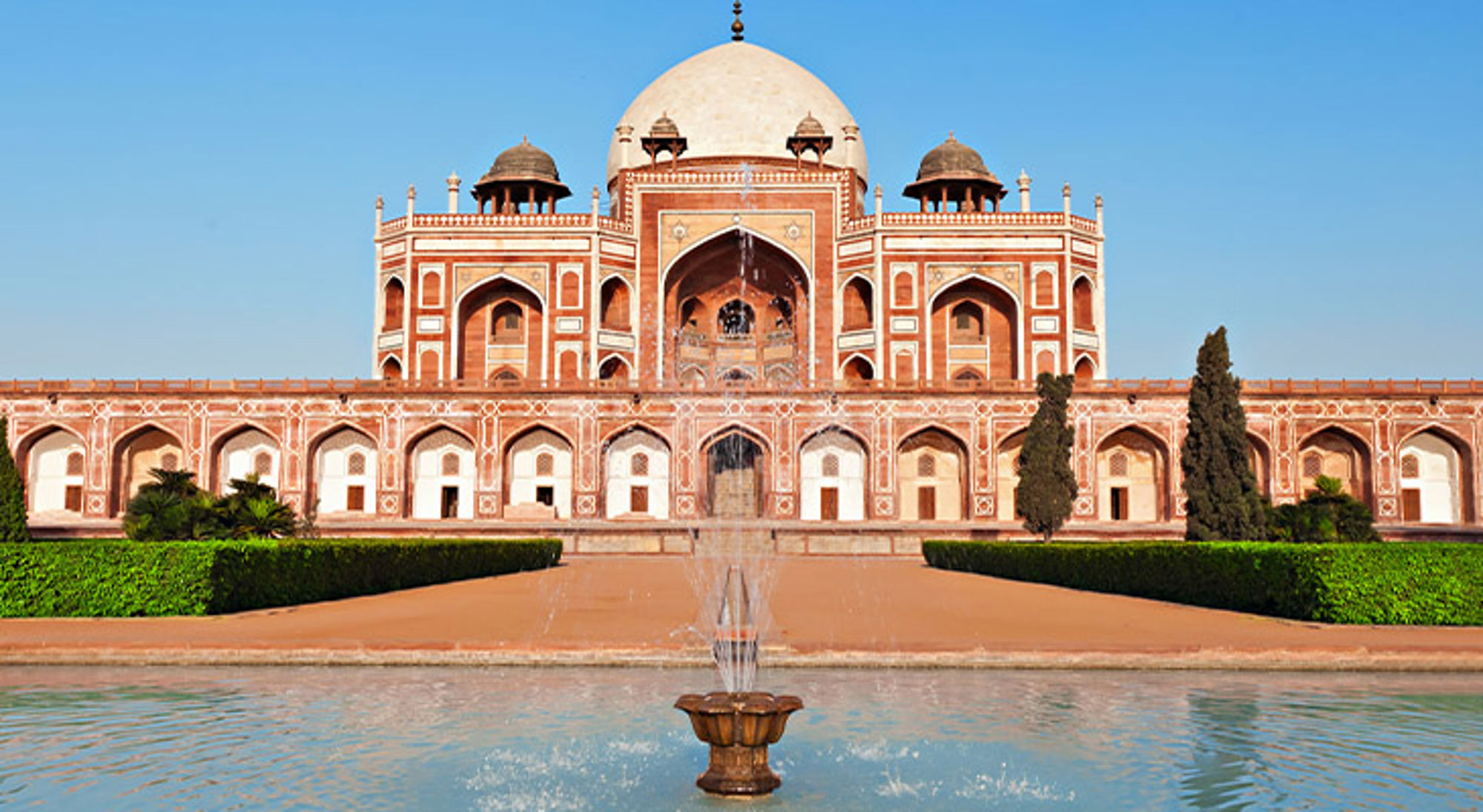 Delhi India Humayun's Tomb in Delhi met fontein en vijver op de voorgrond onder een heldere blauwe lucht.
