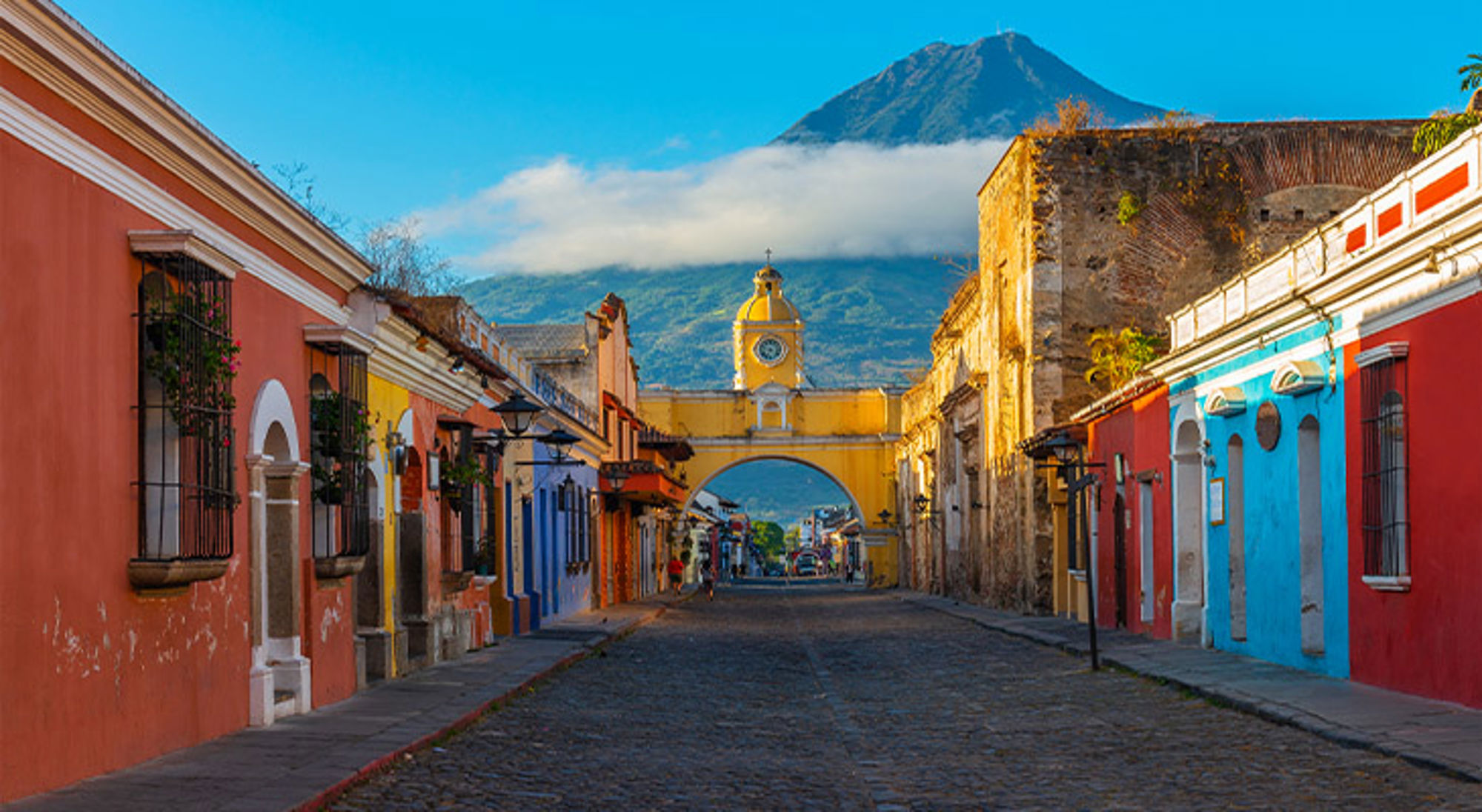 Antigua, Guatemala Straat met kleurrijke gevels en de Santa Catalina-boog in Antigua Guatemala, met de Agua-vulkaan op de achtergrond.