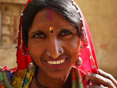 Portret van een vrouw met rode sluier en sieraden tijdens de festivalreis Noord-India en Nepal.