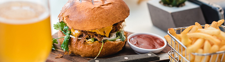 Burger met friet en ketchup, geserveerd met een glas bier, als smaak van Noord-Amerika.