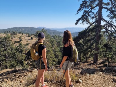 Wandelaars met rugzak genieten van uitzicht over het Troödosgebergte tijdens de wandelreis op Cyprus.