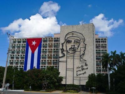 Gevel van het Ministerie van Binnenlandse Zaken in Havana met Che Guevara-portret en Cubaanse vlag.