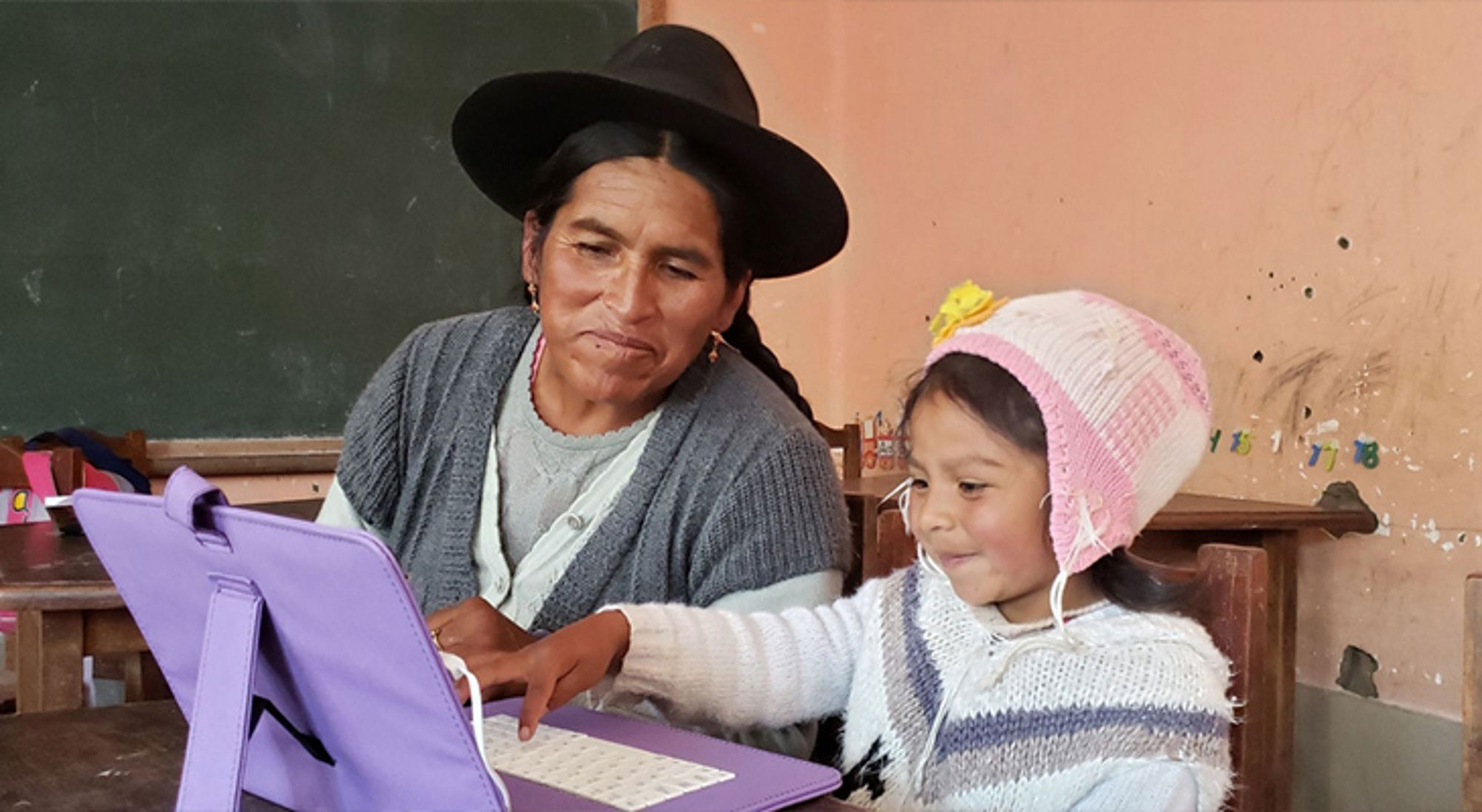 Amigos de Potosí Vrouw en kind gebruiken een tablet in een klaslokaal.