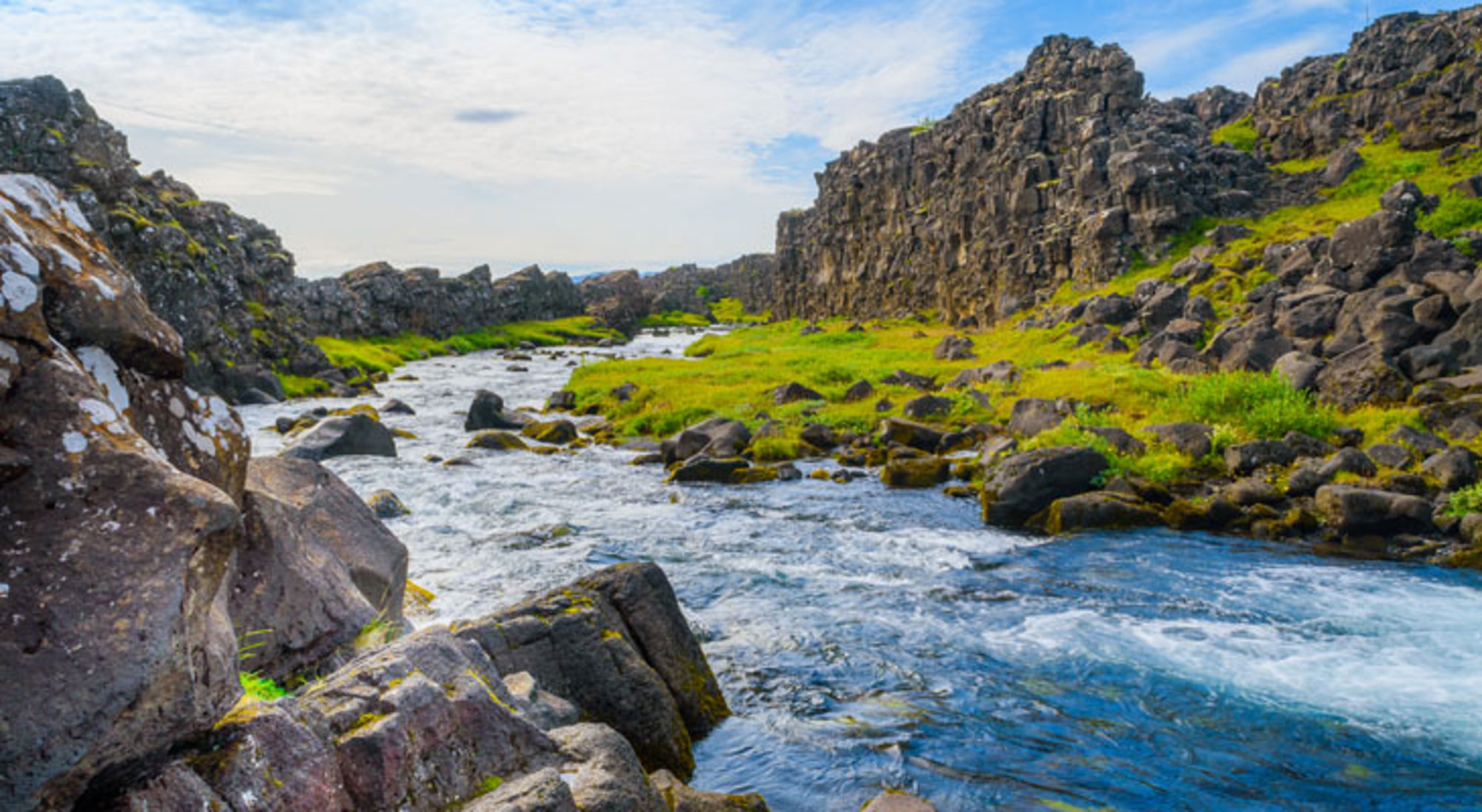 Thingvellir IJsland Rivier in een rotsachtig landschap met groene oevers in IJsland.