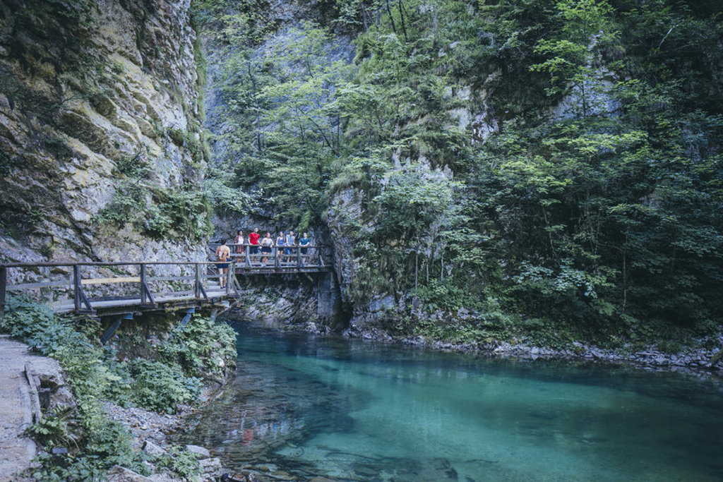 Wandelpad langs een turquoise rivier in een kloof in Slovenië, ideaal tijdens een fietsvakantie.