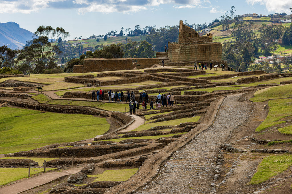Inca-ruïnes van Ingapirca in de Andes, Ecuador, met bezoekers tussen de terrassen en het ronde tempelgebouw.