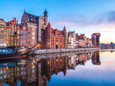 Zonsondergang bij de oude binnenstad van Gdańsk met historische pakhuizen langs de rivier de Motława.