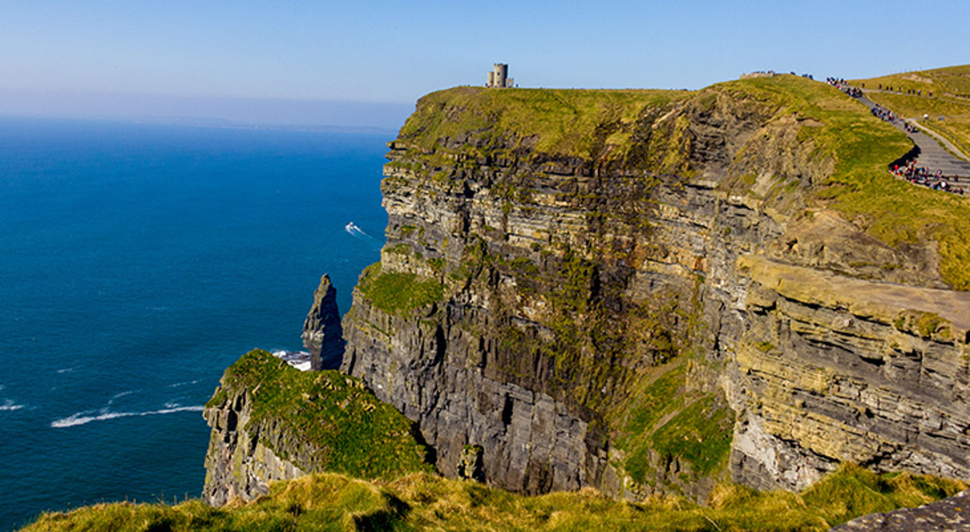 Cliffs of Moher, Ierland Uitzicht op de Cliffs of Moher aan de Ierse westkust, met wandelpad en O’Brien’s Tower boven op de kliffen.