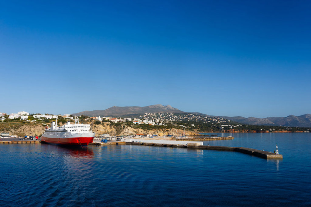Ferry in de haven van Naxos met kustplaats en bergen op de achtergrond, Griekenland.